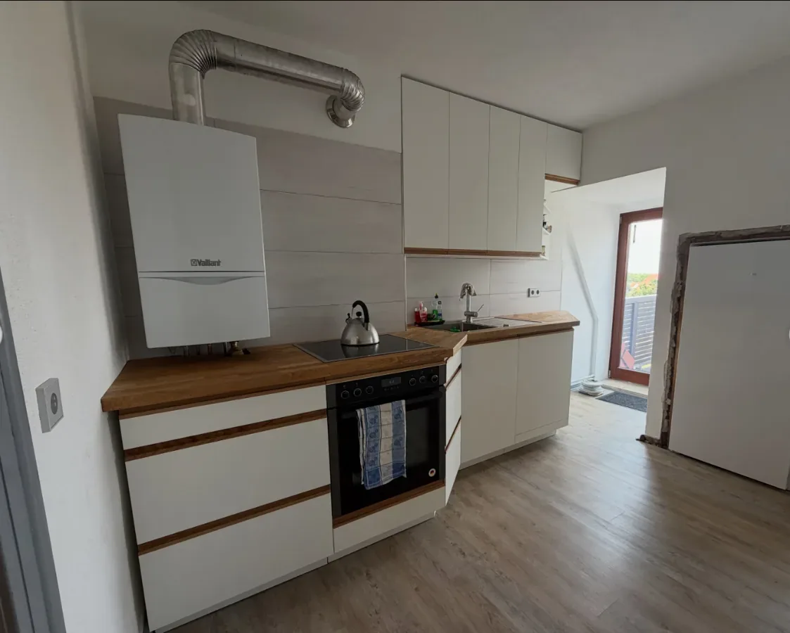 Küchenzeile mit Massivholz-Arbeitsplatte und Blick zum Balkon